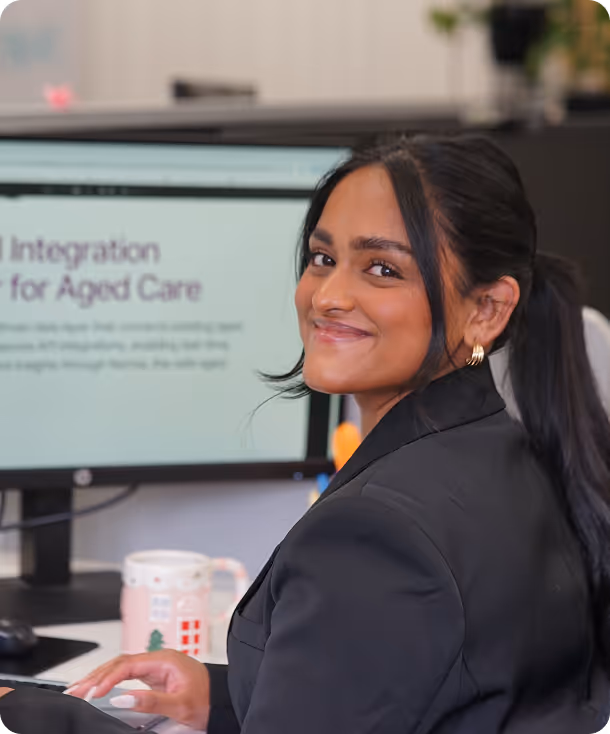 Smiling professional using aged care integration software.